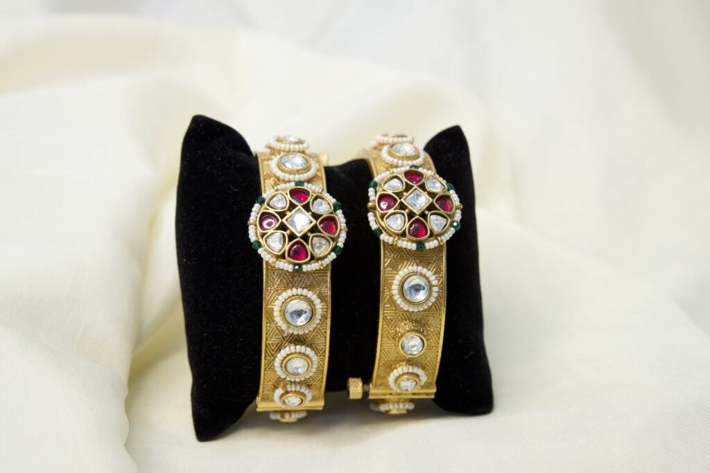 Traditional Gold-Toned Kundan Bangles with Red and Green Stone Embellishments