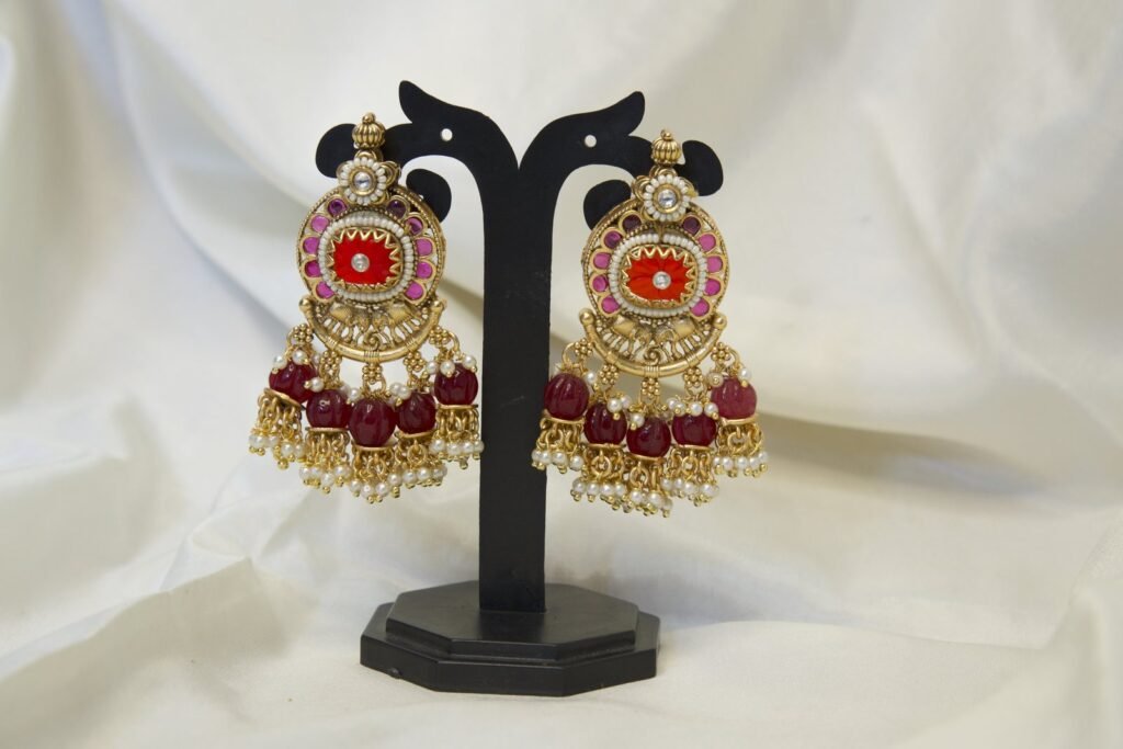 Traditional Gold-Toned Jhumka Earrings with Red and Pearl Embellishments