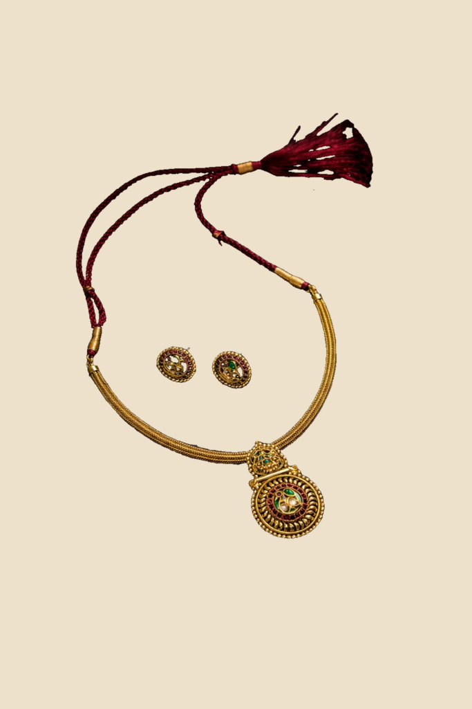 Traditional Gold-Toned Necklace Set with Green Stone Pendant and Maroon Thread Detailing